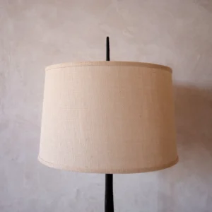 Handcrafted lamp with a bronze base and refined linen shade. Combines artisanal craftsmanship with contemporary design. Perfect for any decor.