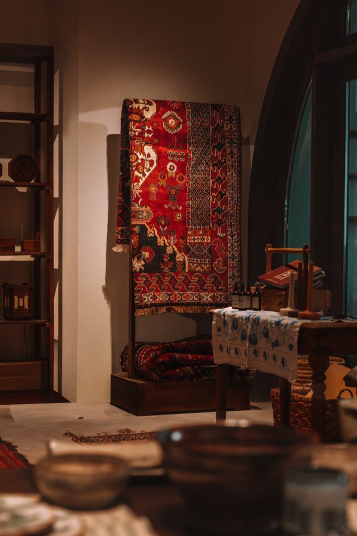 Richly patterned rugs and handcrafted objects in a softly lit stall