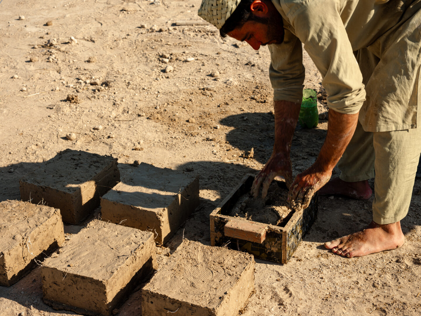 Shaping earth bricks by hand at the farm