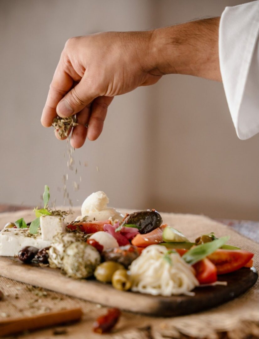 A chef seasoning a seasonal farm-to-table sharing platter