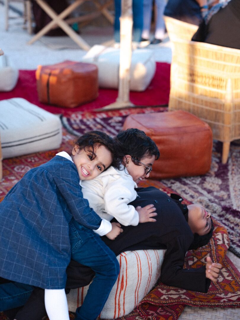 Children relaxing together on floor cushions and rugs