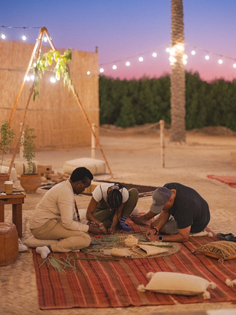 Families gathered on carpets under string lights