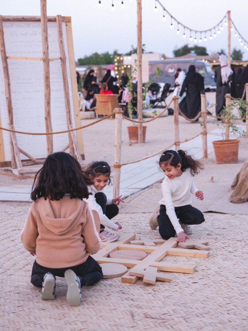 Children playing in the sand between the stalls