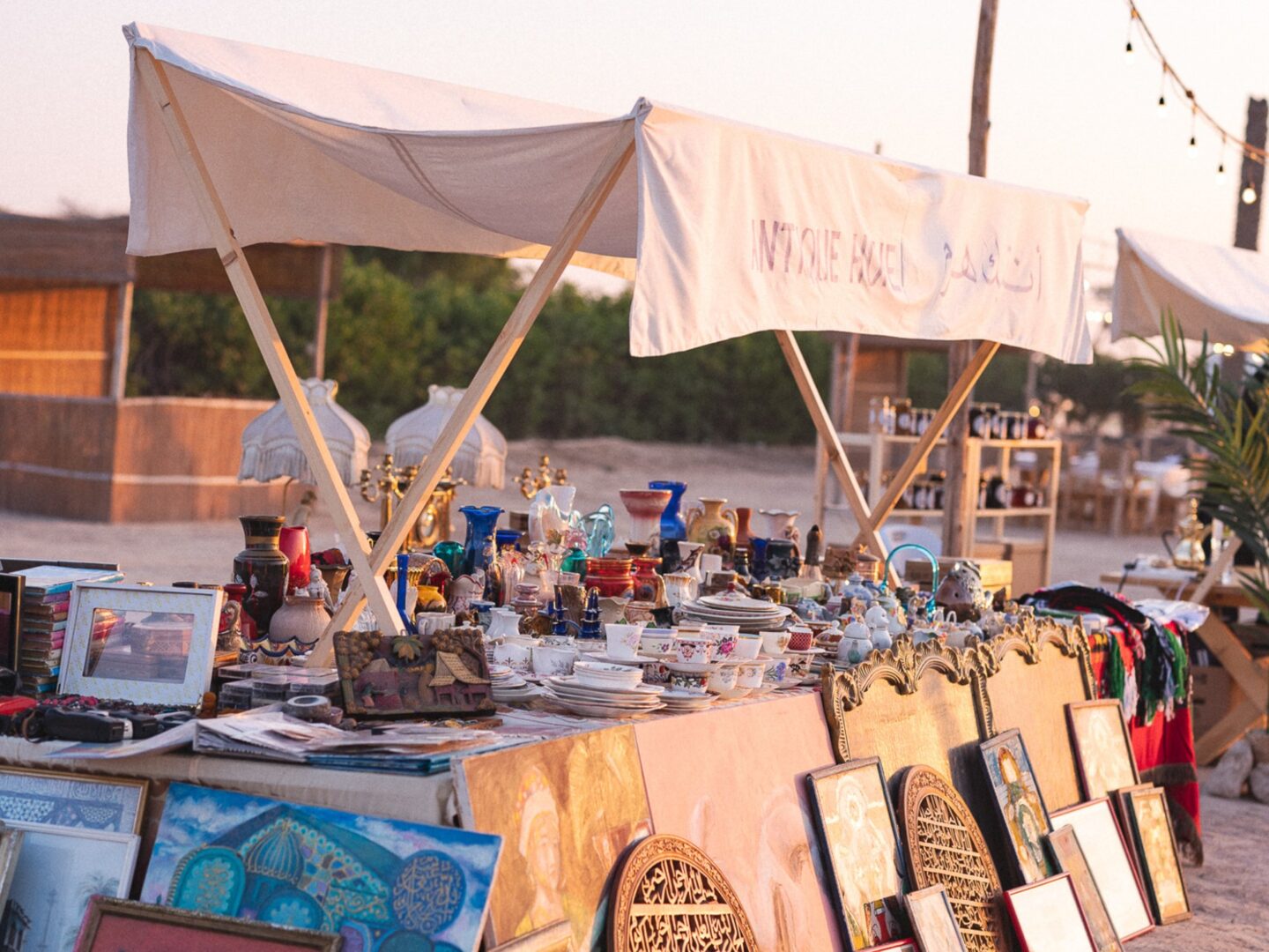 A bazaar stall displaying handcrafted pieces under a canvas canopy